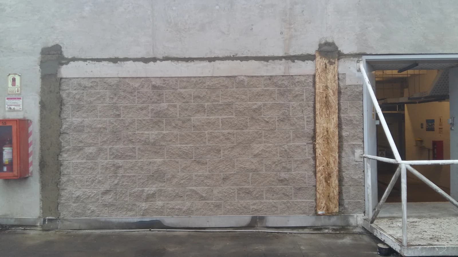 Pared de bloques de concreto confinada con viga collarín tarrajeada arriba y columna lateral en Tottus Pachacútec al amanecer