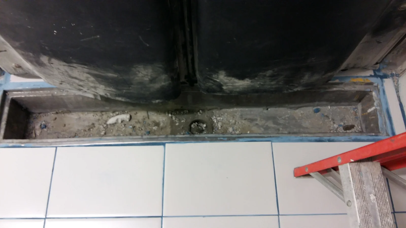 Botadero de Tottus Jockey Plaza terminado con paredes y piso de cerámica blanca y luz cenital — vista frontal del ambiente