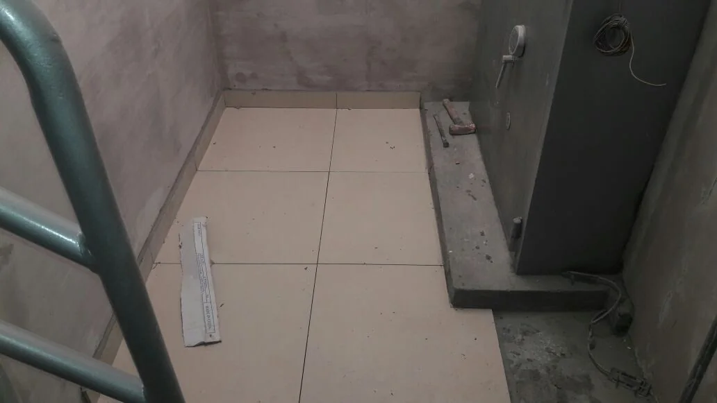 Recinto terminado de caja transfer en Tottus Mega Plaza con puerta acorazada gris y piso de porcelanato beige recién instalado